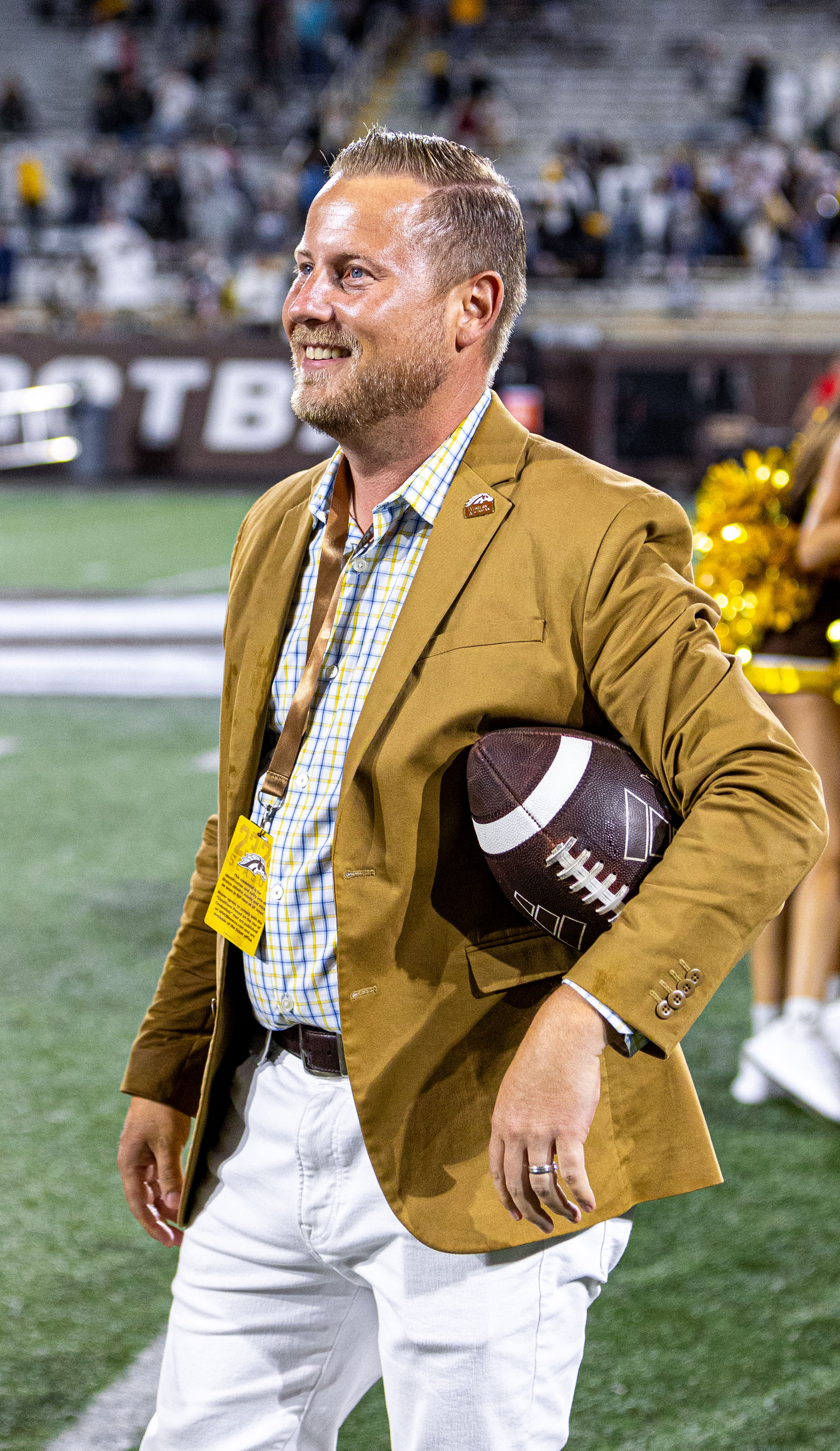 Dan Bartholomae on field holding a football